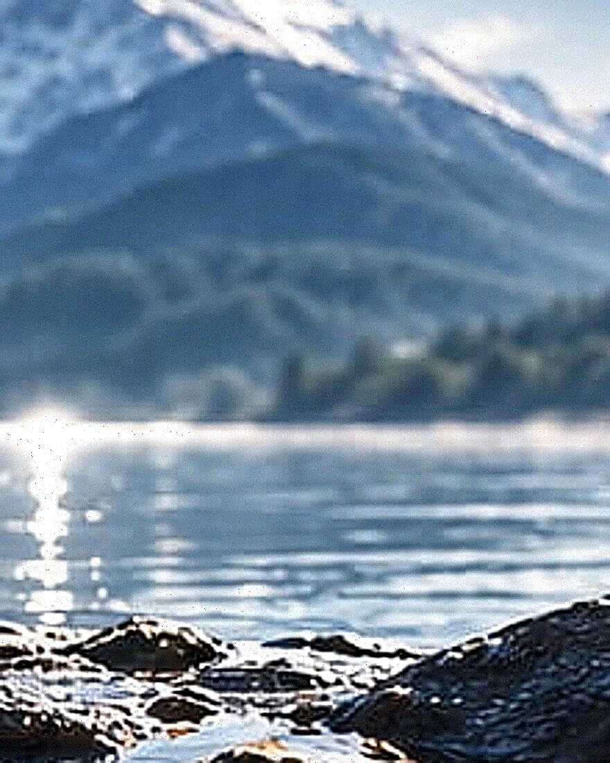 Snow-capped mountains rising above a still alpine lake